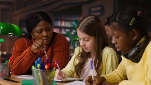 female teacher assisting pupils with class homework mentoring (1)